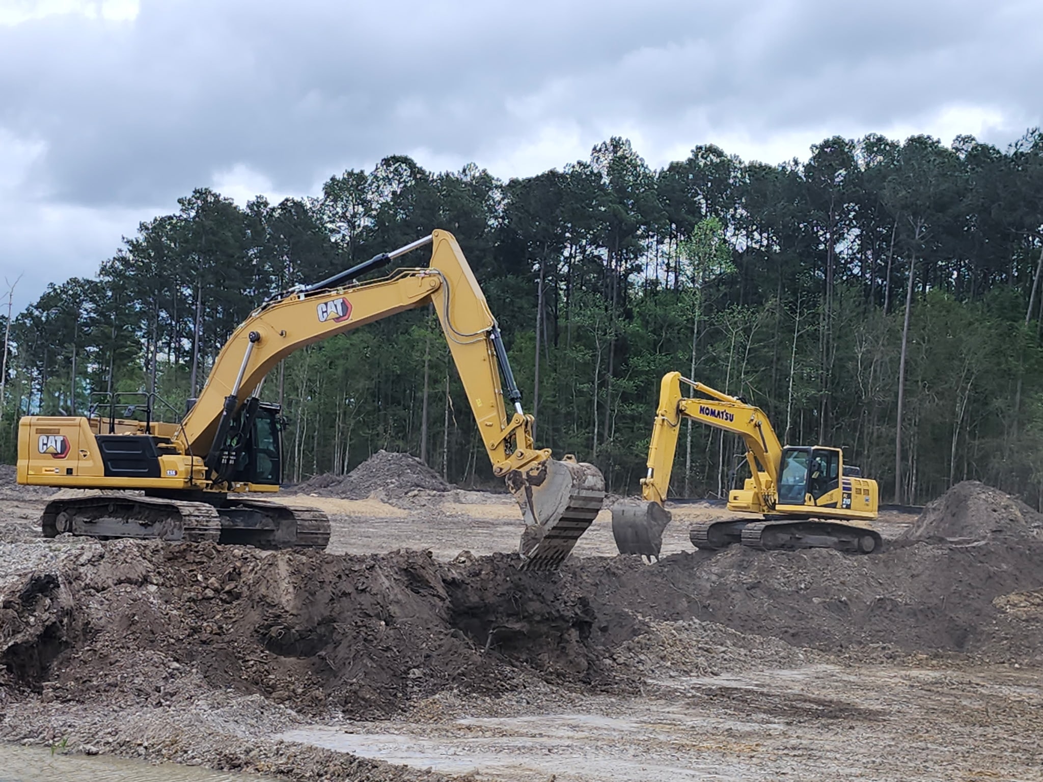 Two excavators working side by side on site